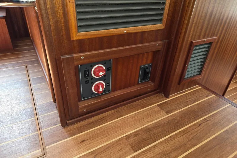 Slide: The Image of 2009 American Tug 34 Rare Flybridge Model interior with wood paneling and control switches. - 92