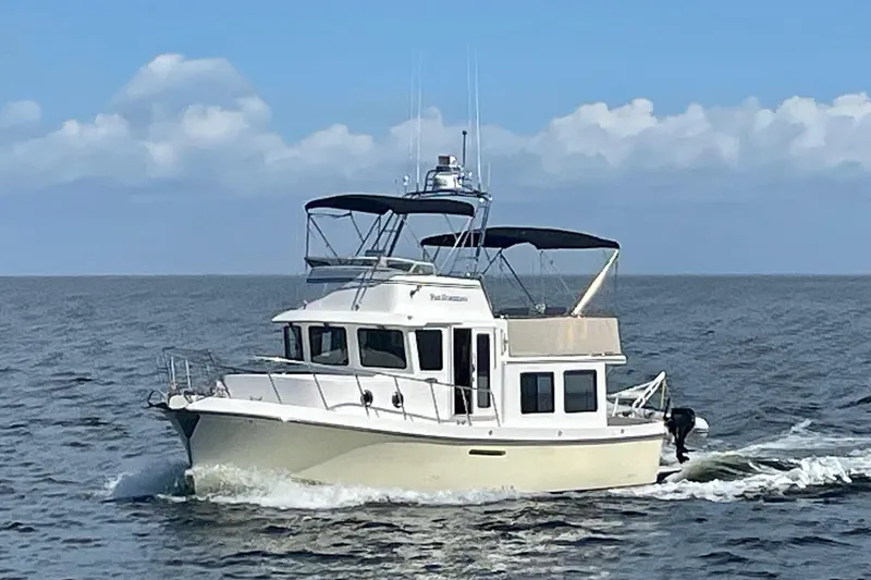 Slide: The Image of 2009 American Tug 34 Rare Flybridge Model cruising on open water under a clear sky. - 97