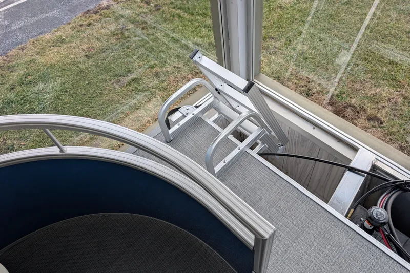 Slide: The Image of Aluminum ladder on SunChaser Vista 16 LR pontoon boat, 2026 model, near grassy area. - 10