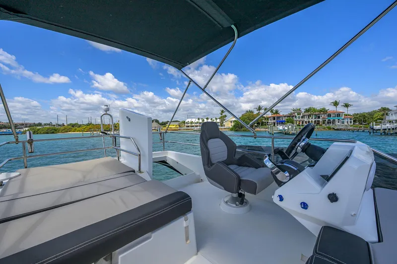 Slide: The Image of Flybridge view of 2022 Jeanneau NC Weekender 1095 Fly, featuring helm and seating area. - 10