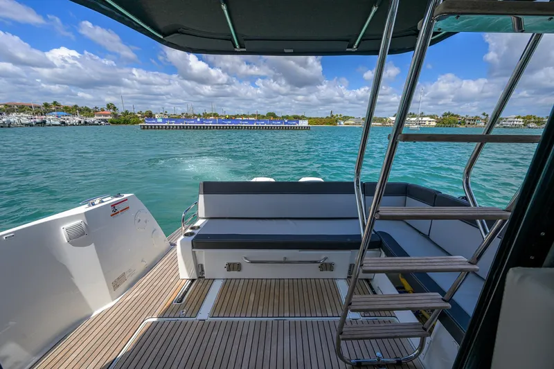 Slide: The Image of 2022 Jeanneau NC Weekender 1095 Fly boat interior with seating and ladder, overlooking water. - 16