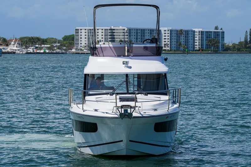 Slide: The Image of 2022 Jeanneau NC Weekender 1095 Fly cruising on a sunny day near waterfront buildings. - 2