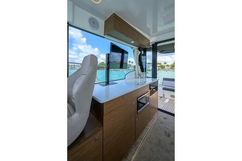 Slide: The Image of Interior of 2022 Jeanneau NC Weekender 1095 Fly, featuring modern kitchen and scenic water view. - 22