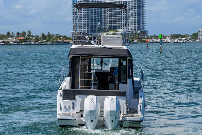 Slide: The Image of 2022 Jeanneau NC Weekender 1095 Fly cruising on water with cityscape backdrop. - 3