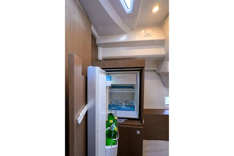 Slide: The Image of 2022 Jeanneau NC Weekender 1095 Fly interior with open fridge and bottled drinks. - 36