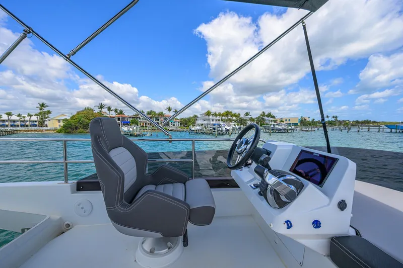 Slide: The Image of Flybridge view of 2022 Jeanneau NC Weekender 1095, overlooking serene waterfront homes. - 8