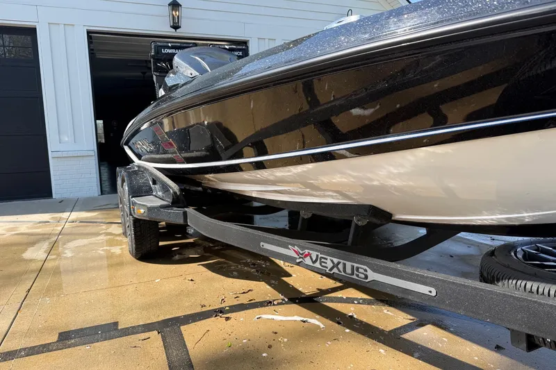 Slide: The Image of 2024 Vexus VXs20 boat on trailer, parked outside a garage. - 11