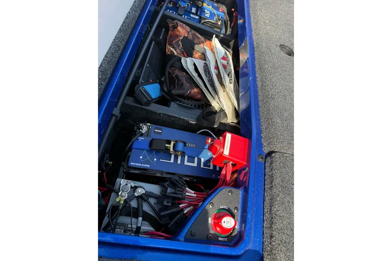 Slide: The Image of 2024 Vexus VXs20 boat storage compartment with batteries and fishing gear. - 16