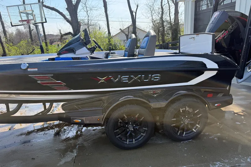 Slide: The Image of 2024 Vexus VXs20 boat on trailer, black with white accents, parked outdoors. - 3