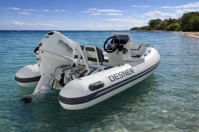 Slide: The Image of Inflatable Desner SP 330 boat with Suzuki motor on clear blue water, 2026 model. - 3