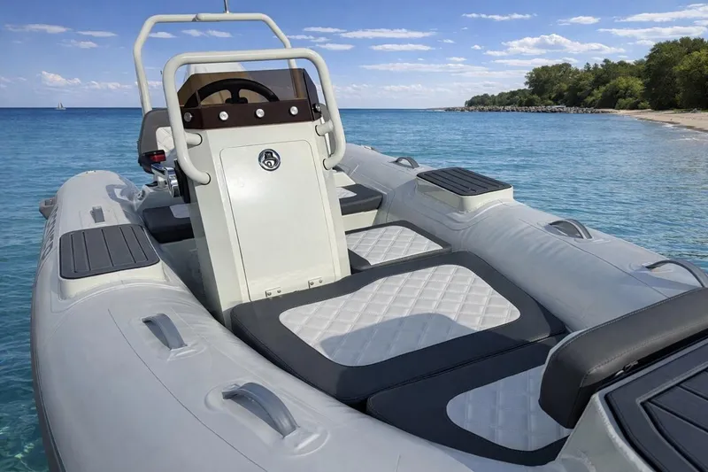 Slide: The Image of 2026 Desner SP 330 inflatable boat on clear blue water near a sandy beach. - 4