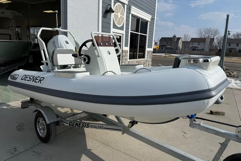 Slide: The Image of 2026 Desner SP 330 inflatable boat on Genesis trailer, parked outside a building. - 8