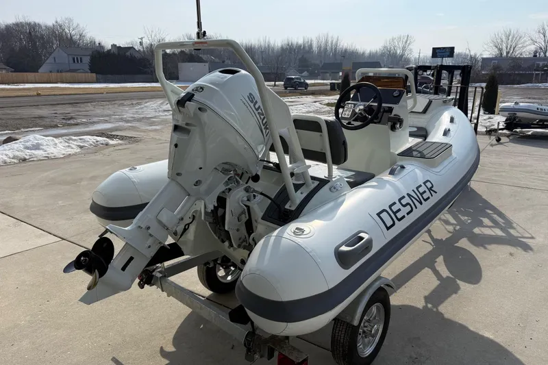 Slide: The Image of Desner SP 330 inflatable boat with Suzuki outboard motor, 2026 model, parked on a trailer. - 9