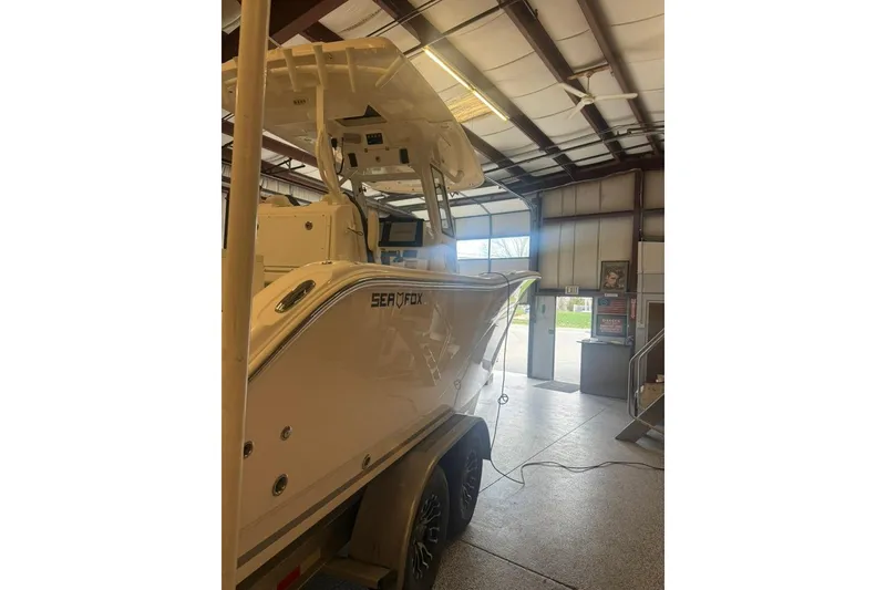 Slide: The Image of 2024 Sea Fox 288 Commander boat in a garage, showcasing sleek design and modern features. - 6