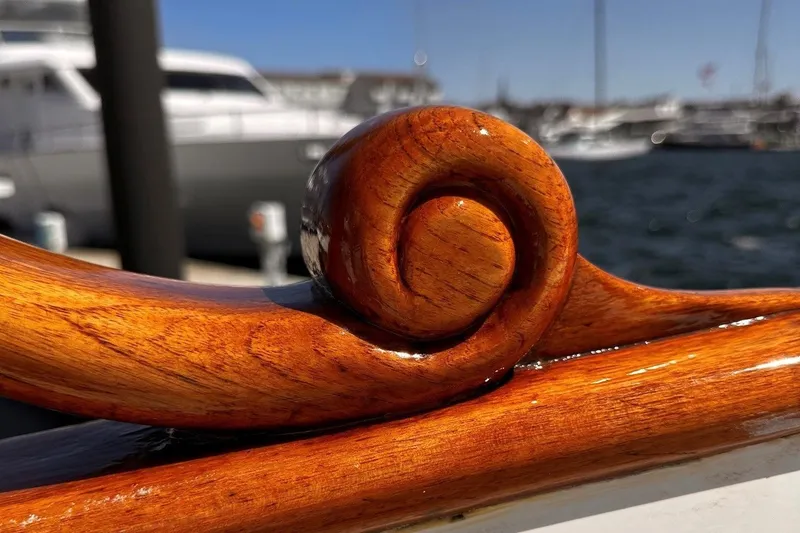 Slide: The Image of Polished wooden detail on a 1994 Grand Banks 42 Classic yacht, with marina background. - 11