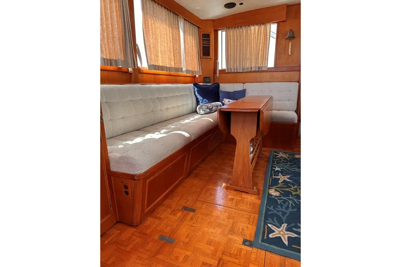 Slide: The Image of Interior of 1994 Grand Banks 42 Classic yacht with wooden furnishings and cushioned seating. - 19