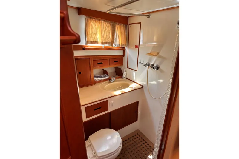 Slide: The Image of Bathroom interior of 1994 Grand Banks 42 Classic yacht, featuring sink, shower, and wooden cabinetry. - 34