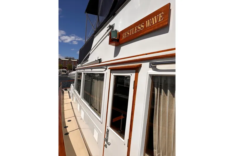 Slide: The Image of Side view of 1994 Grand Banks 42 Classic yacht with "Restless Wave" sign. - 5