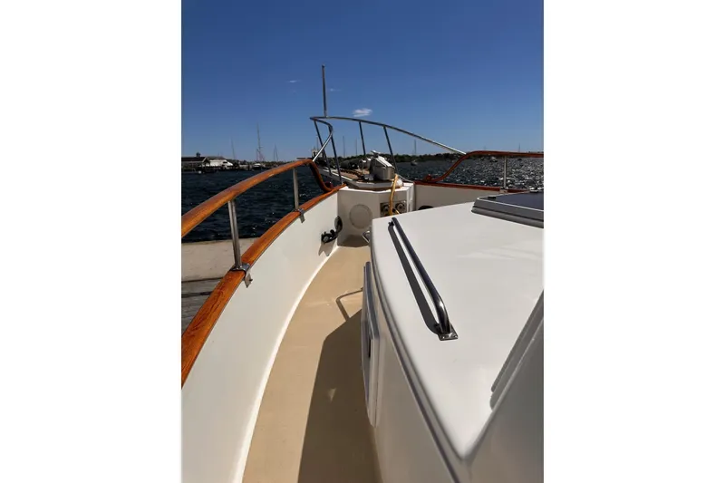 Slide: The Image of 1994 Grand Banks 42 Classic yacht deck with wooden railings, cruising on a sunny day. - 8