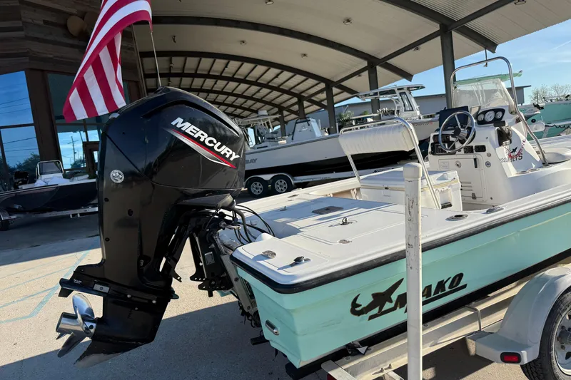 Slide: The Image of 2010 Mako 18 LTS boat with Mercury engine, displayed outdoors under a canopy. - 12