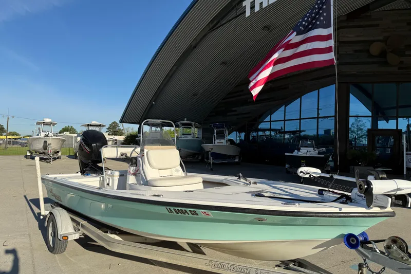 Slide: The Image of 2010 Mako 18 LTS boat on trailer, displayed outside a showroom with American flag. - 3