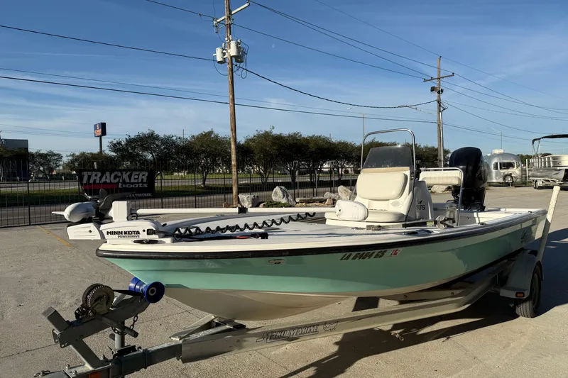 Slide: The Image of 2010 Mako 18 LTS boat on trailer, parked outdoors, featuring Minn Kota trolling motor. - 5