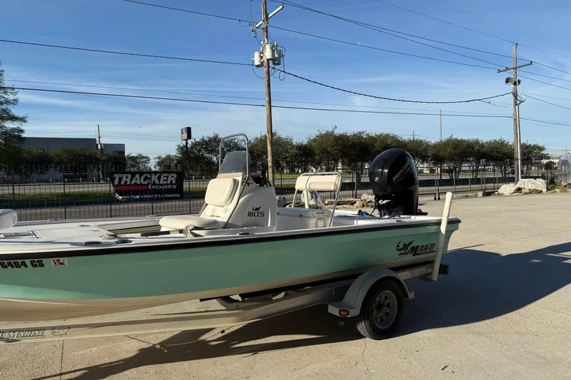 Slide: The Image of 2010 Mako 18 LTS boat on trailer, parked outdoors under clear sky. - 6