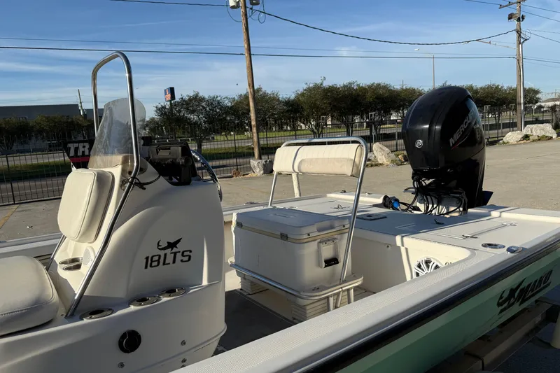 Slide: The Image of 2010 Mako 18 LTS boat with Mercury engine, parked outdoors. - 7