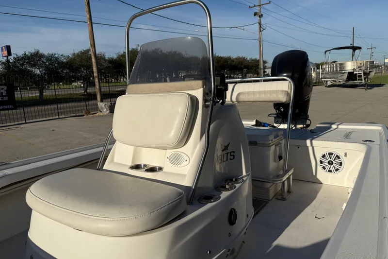 Slide: The Image of 2010 Mako 18 LTS boat interior with seating and console, parked outdoors. - 8