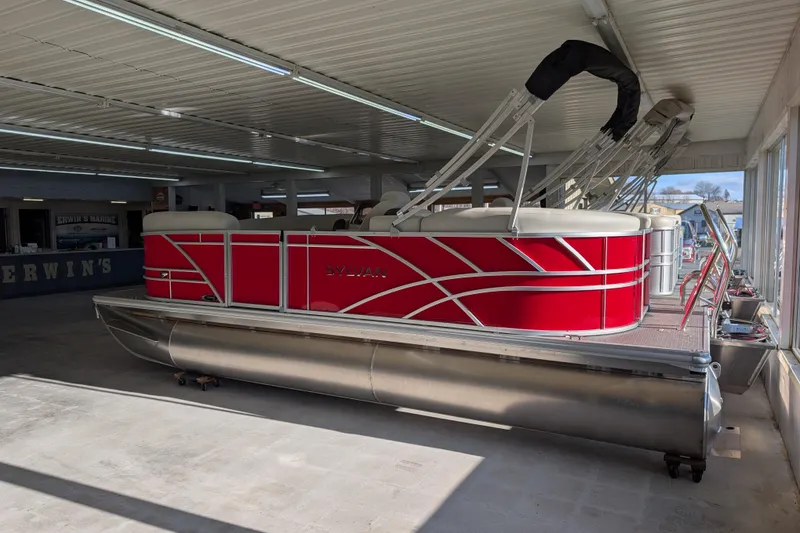 Slide: The Image of 2026 Sylvan Mirage 820 CLZ DH pontoon boat in showroom, featuring vibrant red design. - 2