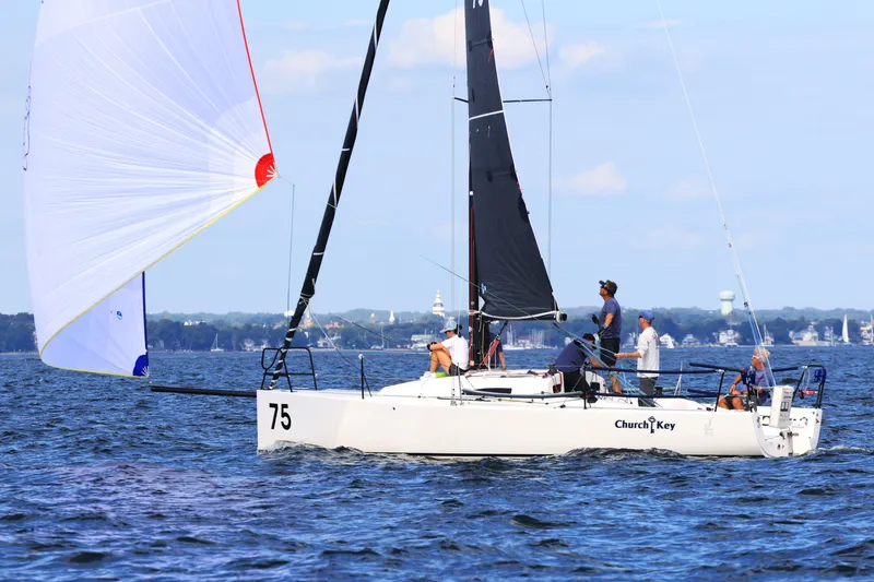 Slide: The Image of 2015 J Boats J/88 sailboat on water, crew onboard, spinnaker deployed. - 3