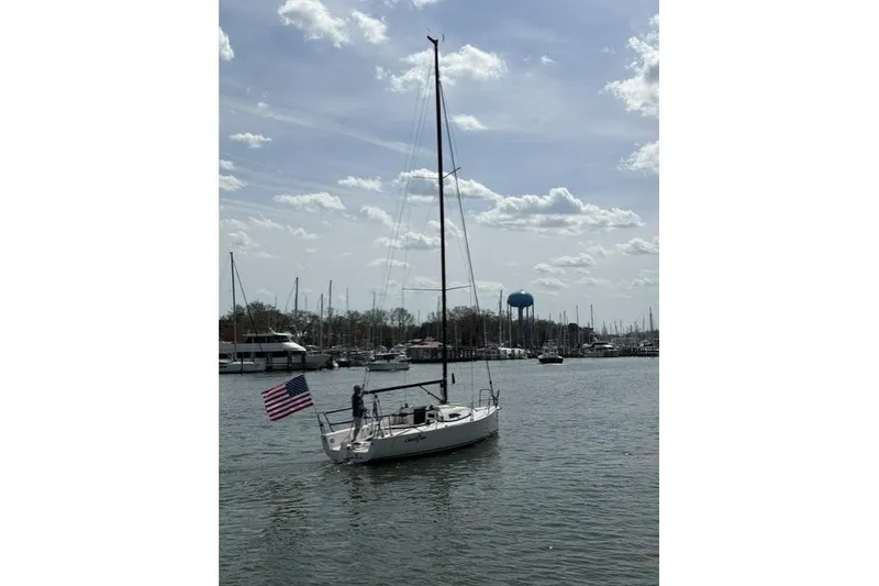 Slide: The Image of 2015 J Boats J/88 sailboat with American flag in a marina setting. - 6