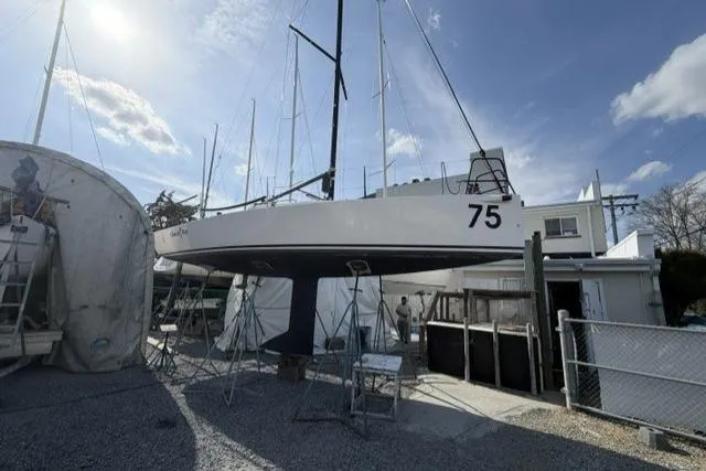 Slide: The Image of 2015 J Boats J/88 sailboat on stands in a boatyard under a clear sky. - 9