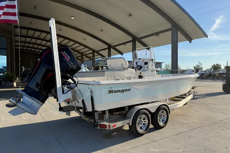 Slide: The Image of 2021 Ranger 2260 Bay Ranger boat on trailer, parked under a large canopy. - 1