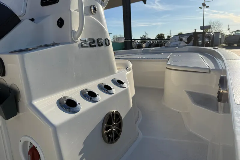 Slide: The Image of 2021 Ranger 2260 Bay Ranger boat interior with rod holders and seating area. - 10