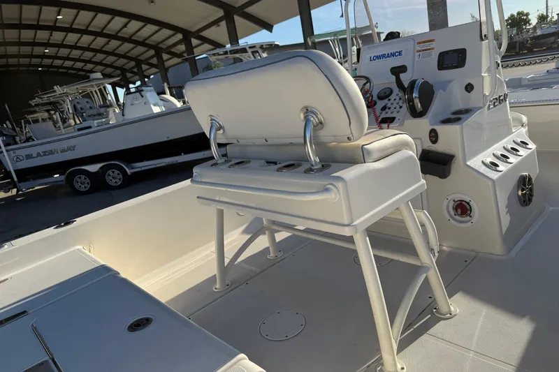 Slide: The Image of 2021 Ranger 2260 Bay Ranger boat interior with helm and seating in a covered marina. - 13