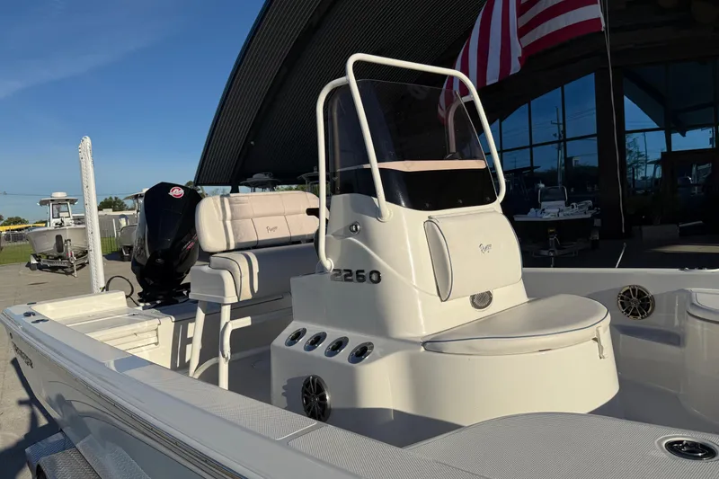 Slide: The Image of 2021 Ranger 2260 Bay Ranger boat with seating and console, displayed outdoors. - 7