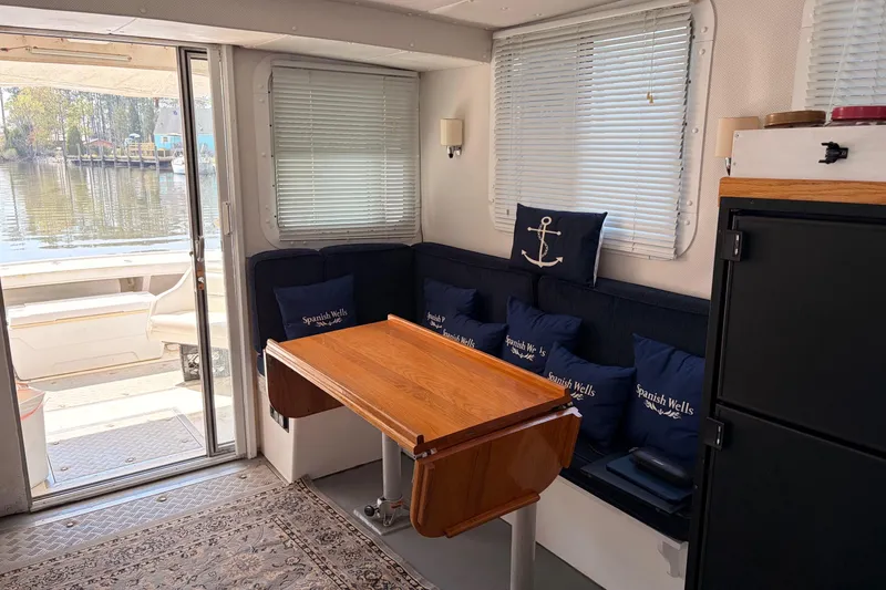 Slide: The Image of Interior of 2000 Provincial 42 Pleasure Boat with dining area and nautical-themed cushions. - 17