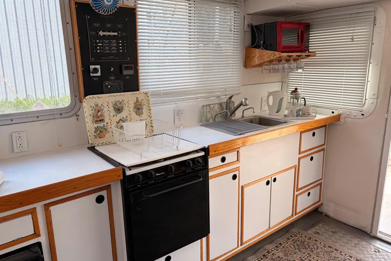Slide: The Image of Interior of a 2000 Provincial 42 Pleasure Boat kitchen with modern appliances and wooden cabinetry. - 26
