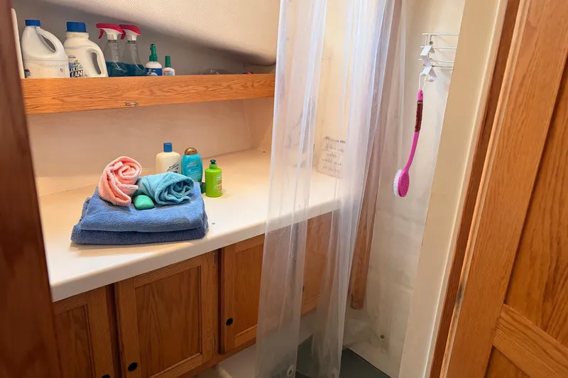 Slide: The Image of Small boat bathroom with toiletries, towels, and cleaning supplies on a Provincial 42 Pleasure Boat. - 41