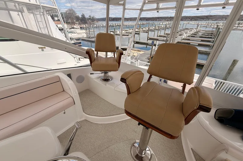 Slide: The Image of Interior of 2015 Viking 42 Open yacht with tan seating and marina view. - 12