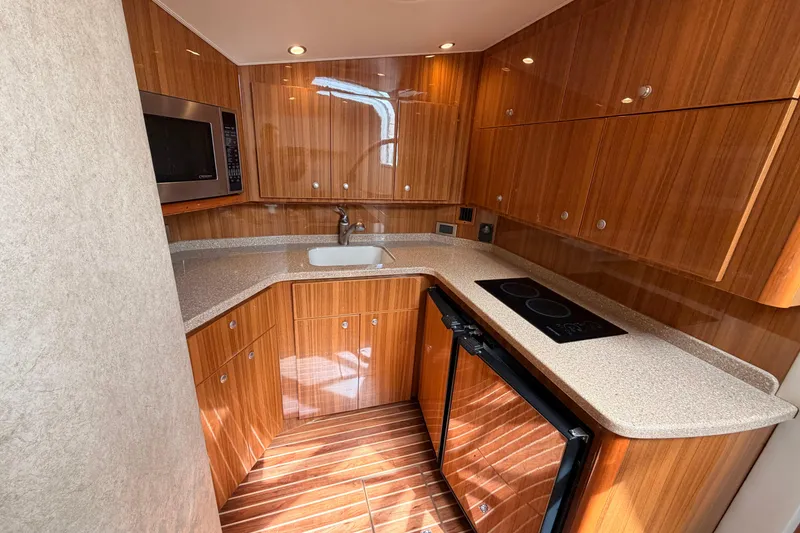 Slide: The Image of Luxurious 2015 Viking 42 Open yacht kitchen with wood cabinetry and modern appliances. - 22