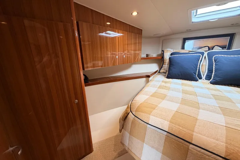 Slide: The Image of Luxurious cabin interior of 2015 Viking 42 Open yacht with wood finish and cozy bedding. - 25