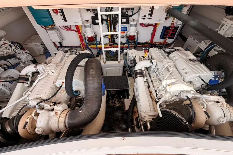 Slide: The Image of Engine room of a 2015 Viking 42 Open yacht, showcasing dual engines and wiring. - 29