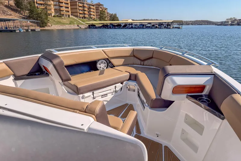 Slide: The Image of 2026 Monterey Elite 30 OB boat interior with luxurious seating on a serene lake. - 13