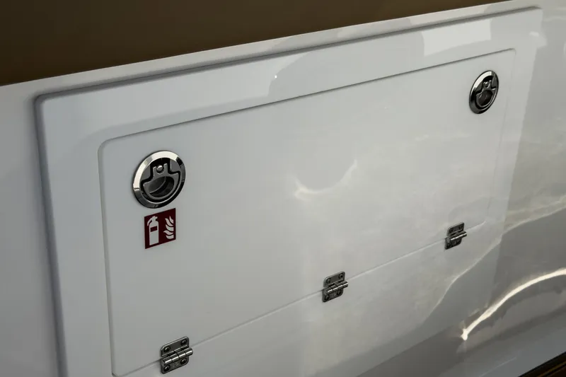 Slide: The Image of 2026 Monterey Elite 30 OB boat compartment with fire extinguisher symbol and chrome handles. - 20