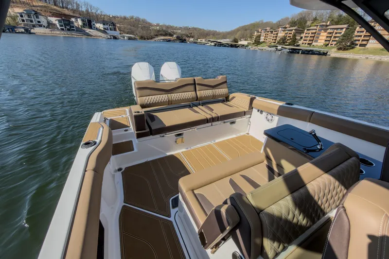 Slide: The Image of 2026 Monterey Elite 30 OB boat interior with luxurious seating on a scenic lake. - 21