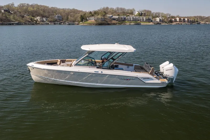 Slide: The Image of 2026 Monterey Elite 30 OB boat on a serene lake with scenic background. - 3