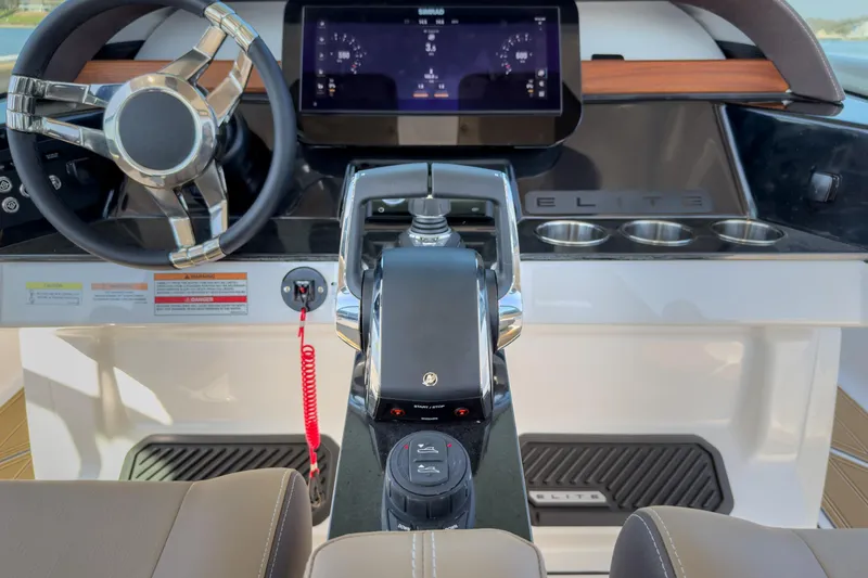 Slide: The Image of Cockpit of 2026 Monterey Elite 30 OB boat with modern steering and control panel. - 30