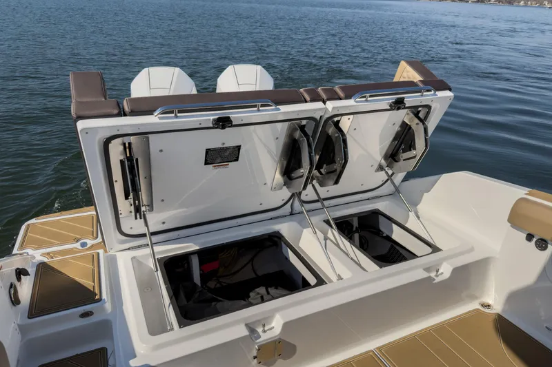 Slide: The Image of 2026 Monterey Elite 30 OB boat with open storage compartments on a calm lake. - 35
